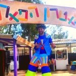 שחקן מתחת לשלט הכניסה של תיאטרון הפארק