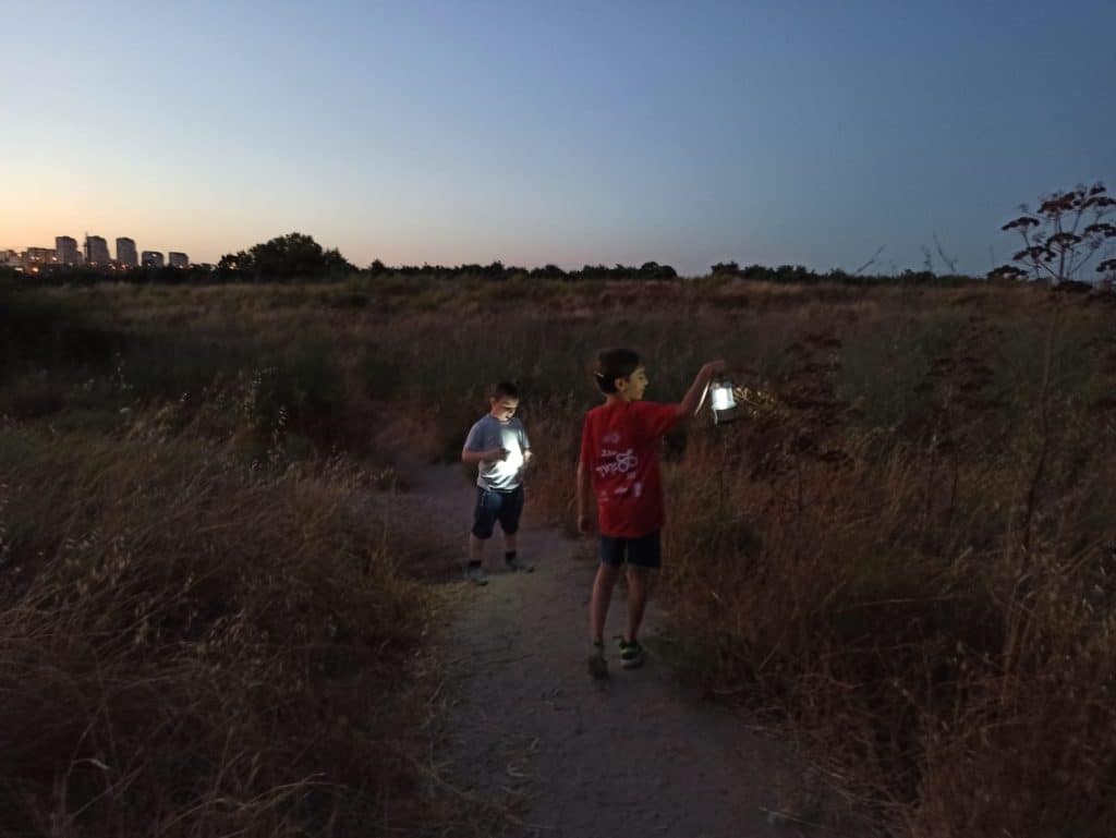 שני ילדים אוחזים בעששית בתל נפוליאון