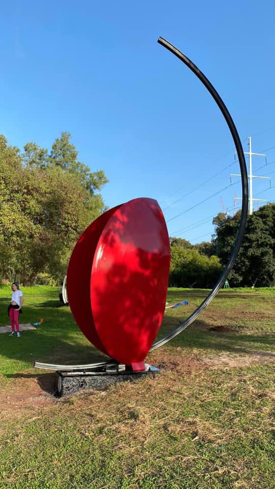 "ללא שם" פסל בצורת מוט חצי מעוגל ובתוכו חצי כדור אדום