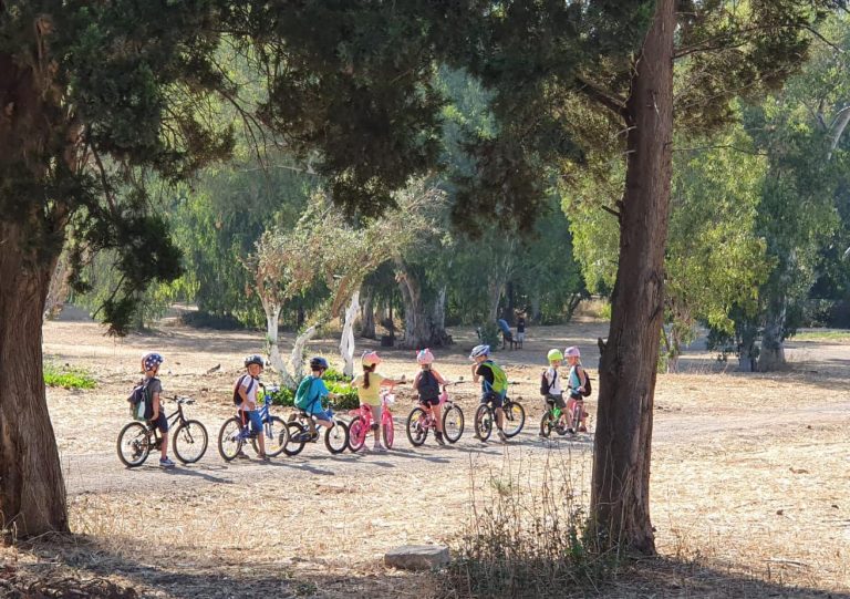 קבוצת ילדים רוכבת על אופניים בפארק