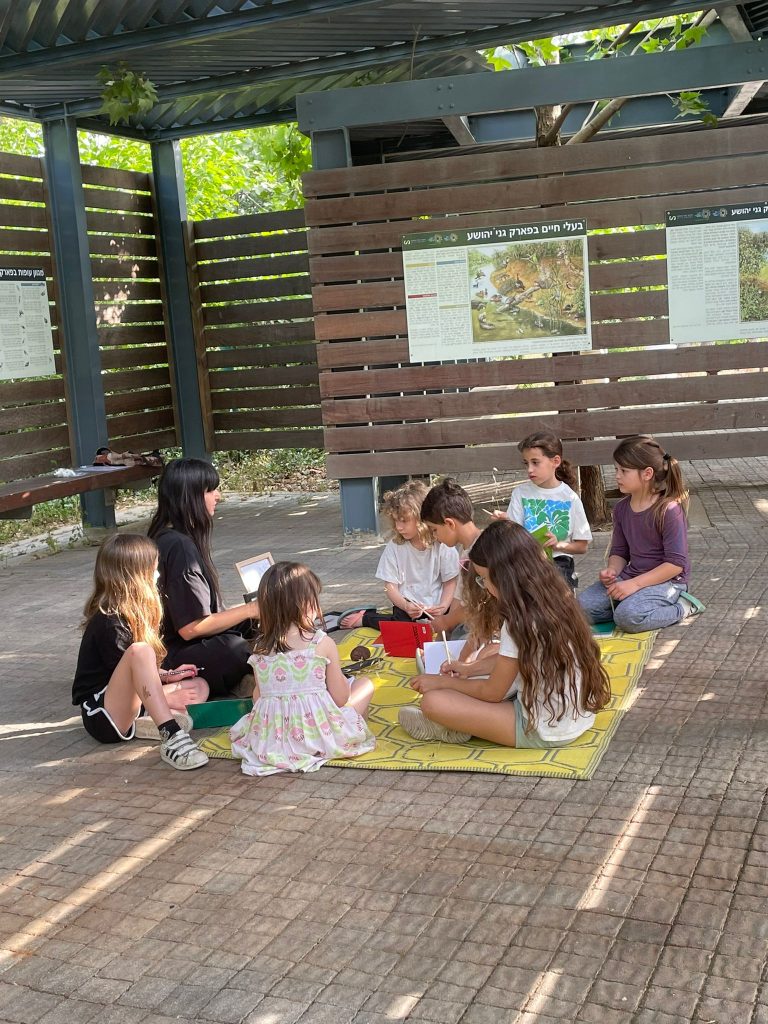 ילדות ואמנית, עם כלי יצירה ברחבת פארק הצפרות.