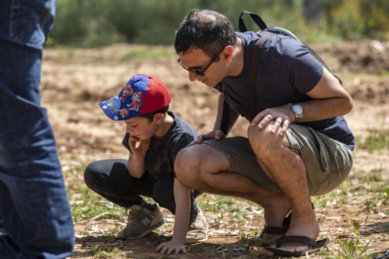 אבא וילד מתכופפים ומתבוננים על משהו