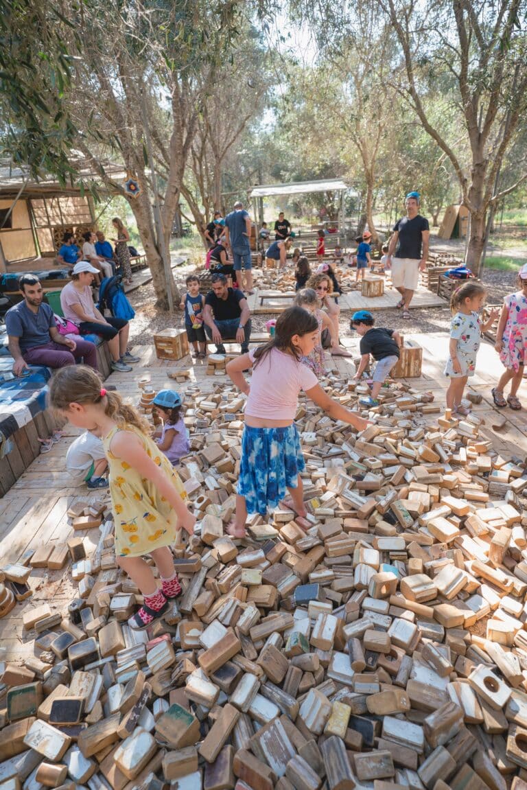 צילום של בית הקוביות ובתוכו משפחות משחקות בקוביות