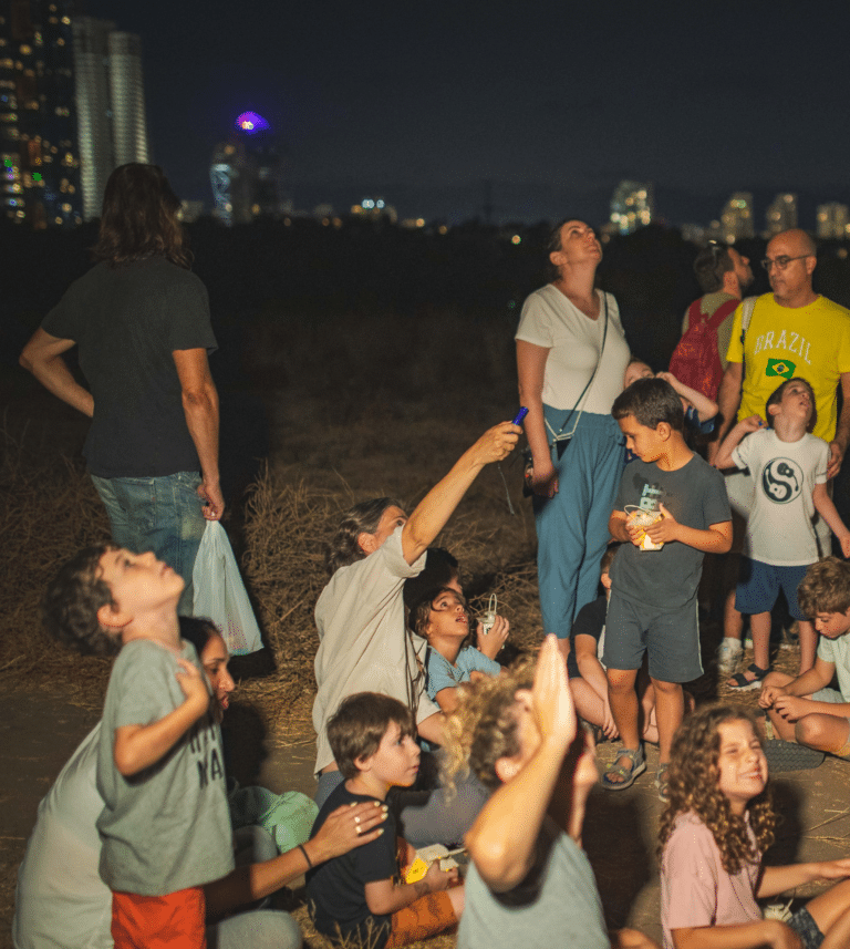 קבוצת ילדים מצביעה שמיים לכיוון הכוכבים