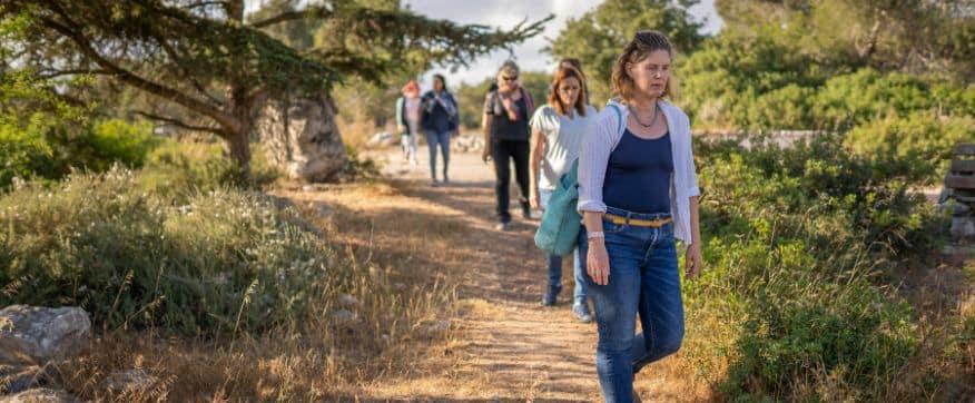 כמה נשים הולכות בטור בטבע עם המדריכה אלה פרסבורג