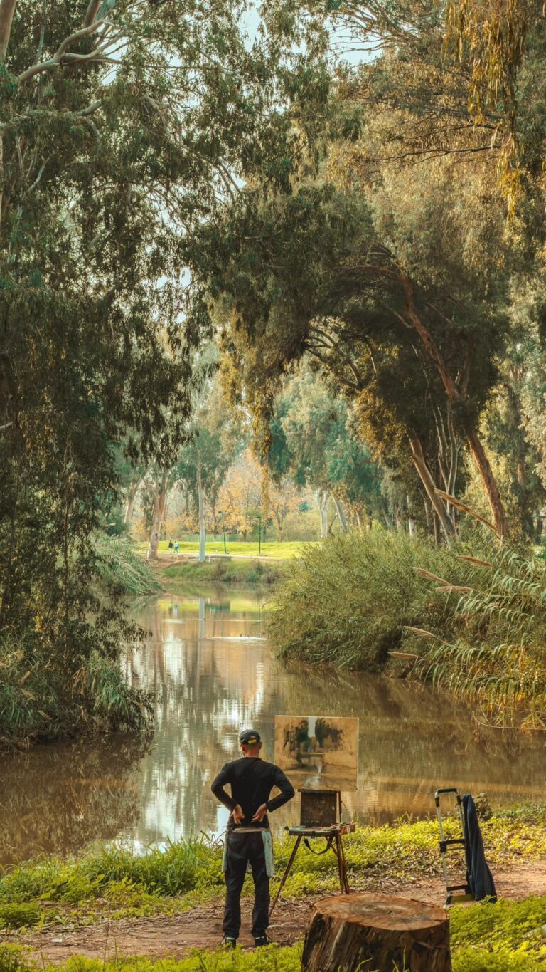 צילום של צייר בעת המנוחה מציור שהוא מצייר על מהשנראה כמו דיקט