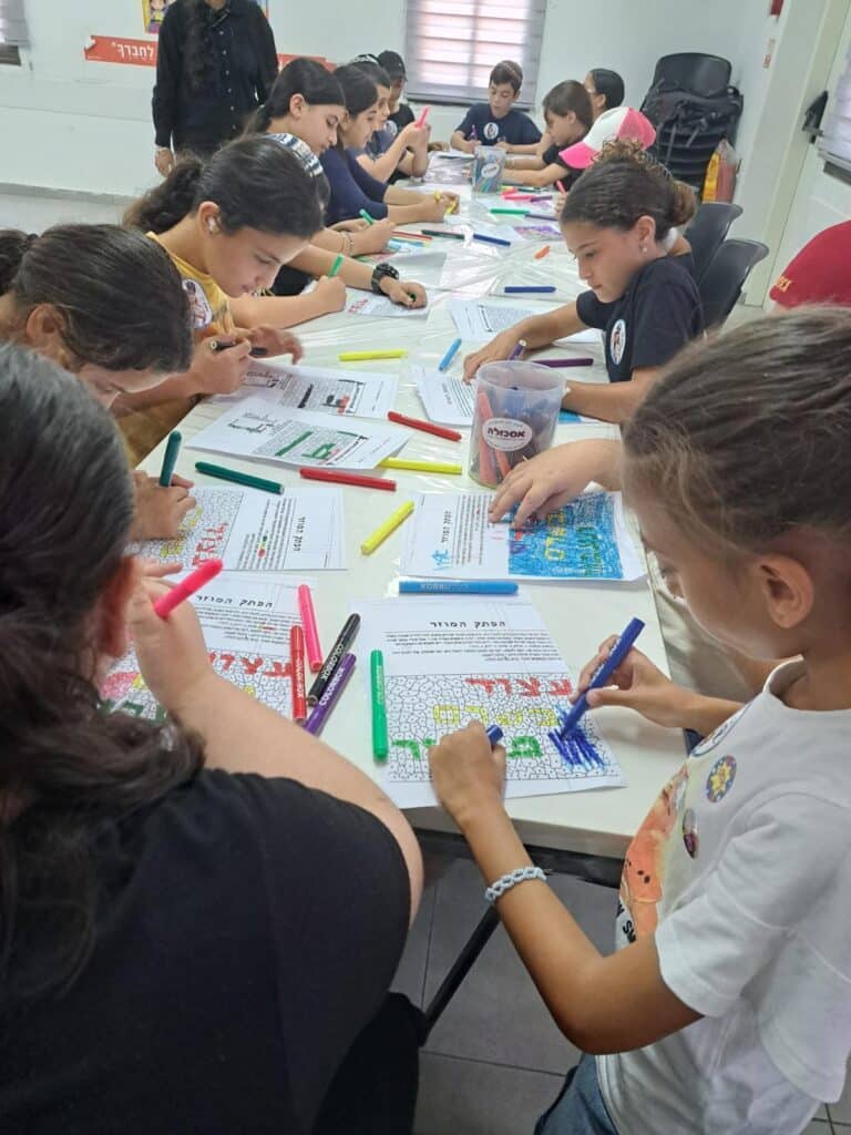 ילדים מציירים על ניירות בכיתה