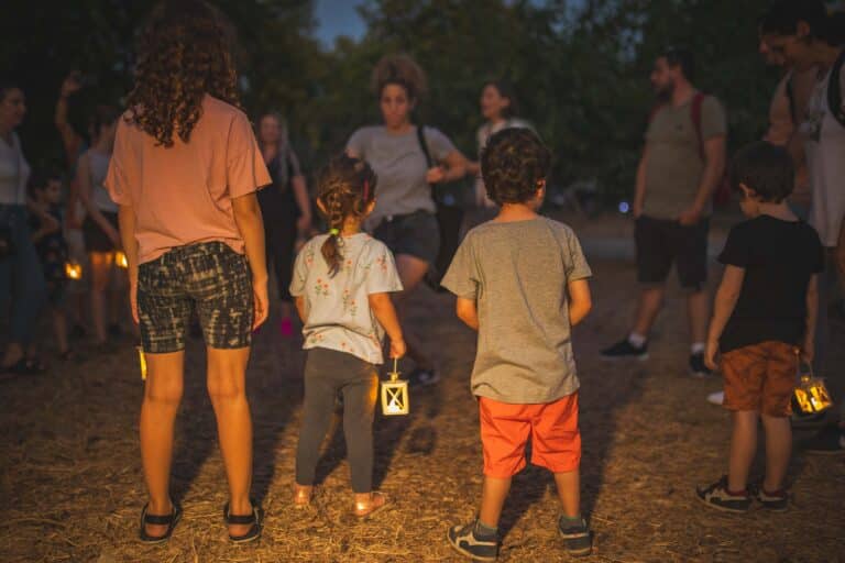 3 ילדים מצולמים מהגב ובידם עששית