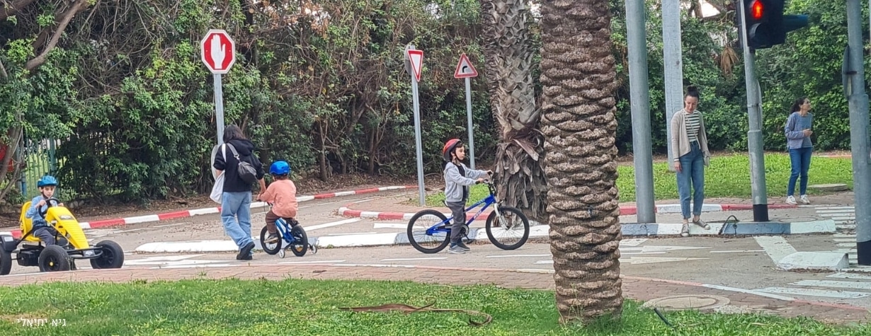 מתחם הילדים לזהירות בדרכים מין צומת וילדים רוכבים על אופניים
