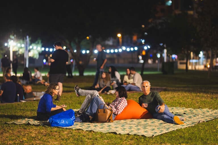 אנשים שרועים על מחצלות על הדשא