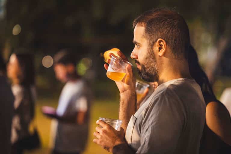 בחור צעיר שותה כוס יין