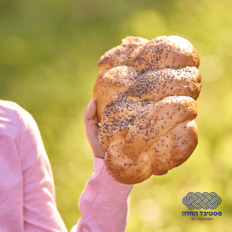 יד אוחזת בחלה אפויה על רקע ירוק