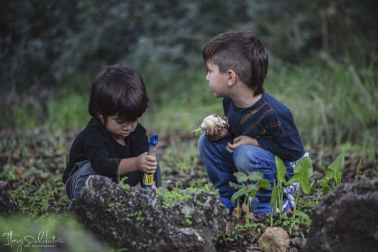 שני ילדים אחד עודר באת הקטנ הואחד מתבונן לצד