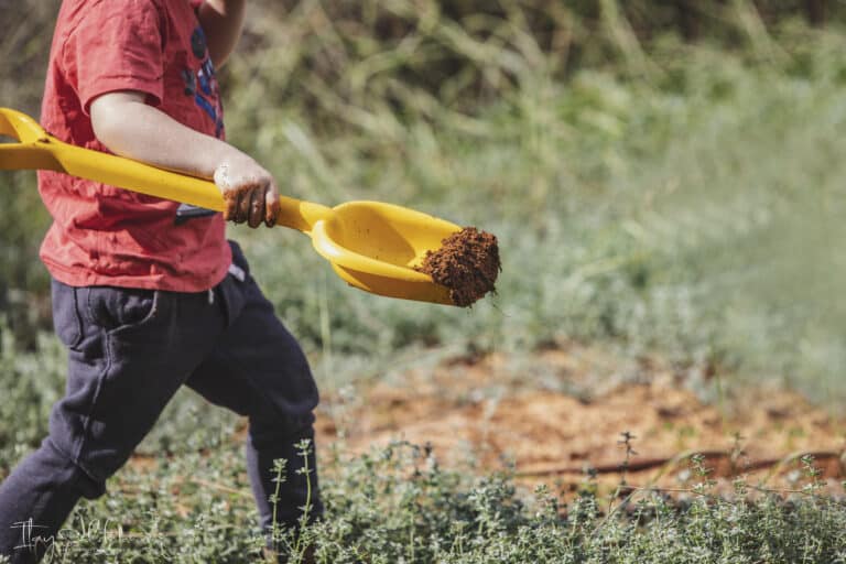 ילד הולך עם את צהובה ובה מעט חול