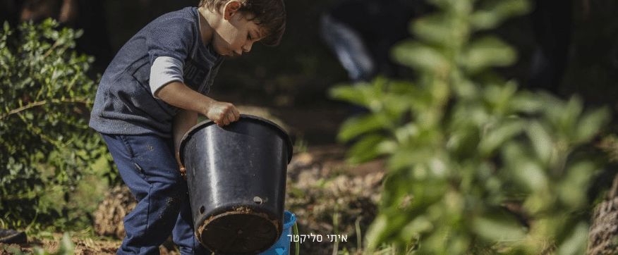 ילד מתכופף לדלי שחור