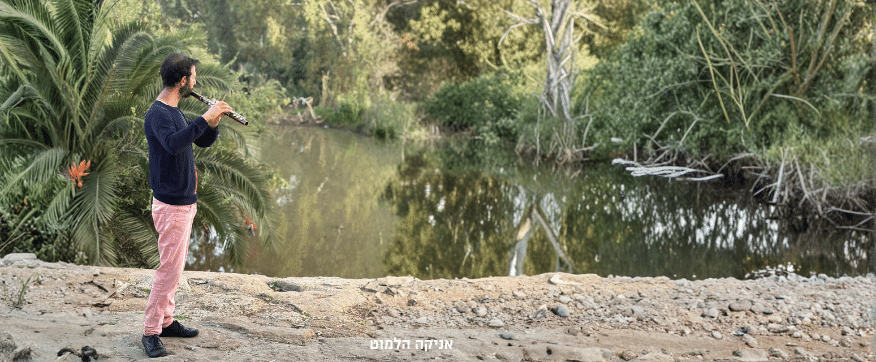 רואי אמוץ - חלילן, מחלל על רקע אגם יפה.