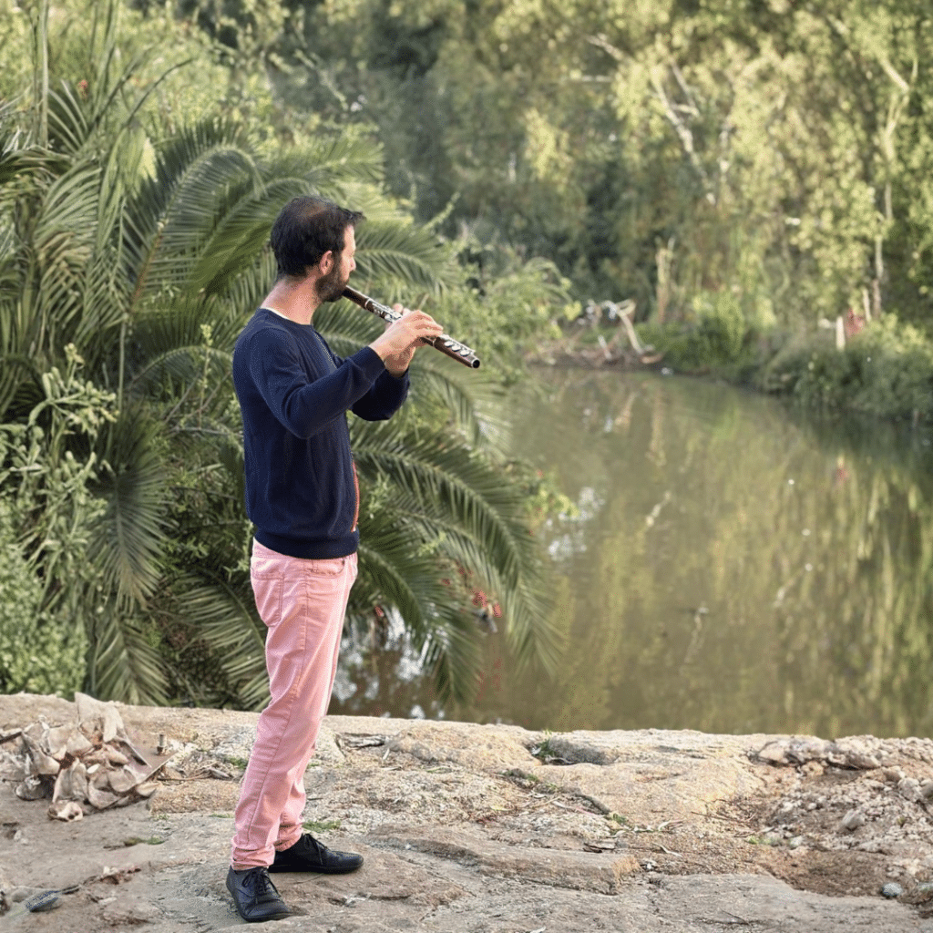 רואי אמוץ - חלילן, מחלל על רקע אגם יפה.