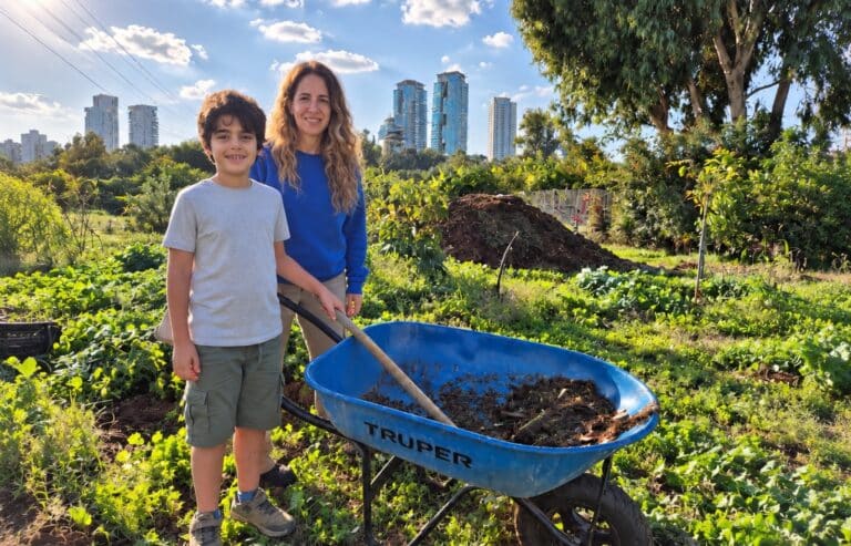 אמא ובן ליד מריצה כחולה בשדה ירקו
